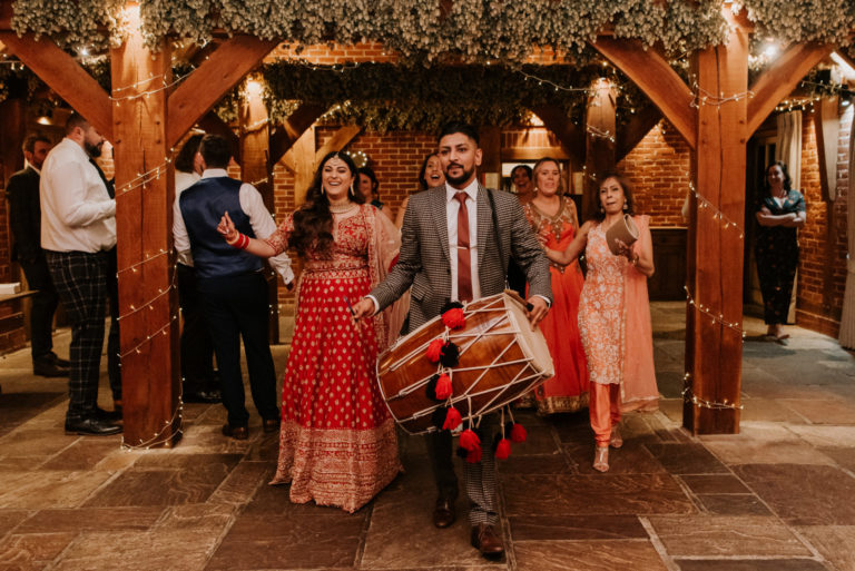 A wedding in Indian traditional dress, during their wedding ceremony at The Ferry House wedding barn in Kent