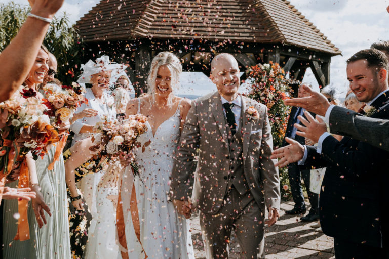 A newly married couple being showered with confetti