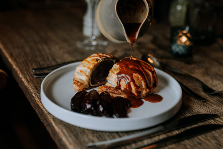 A duck wellington having a jus poured over it at The Ferry House in Kent.
