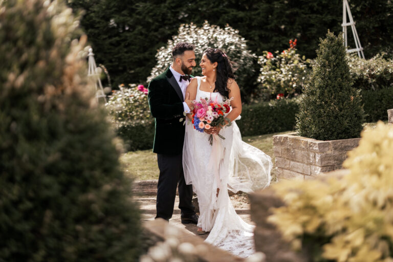 A bride and groom in the Rose Garden at The Ferry House barn wedding venue in Kent.