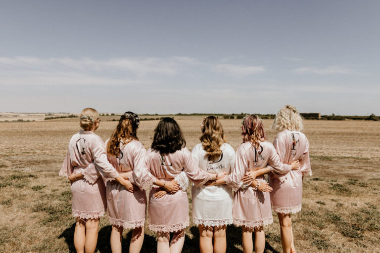 A wedding party standing among the fields of the Mocketts Farm Cottages