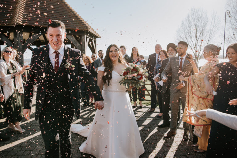 A wedding couple walking under a shower of confetti