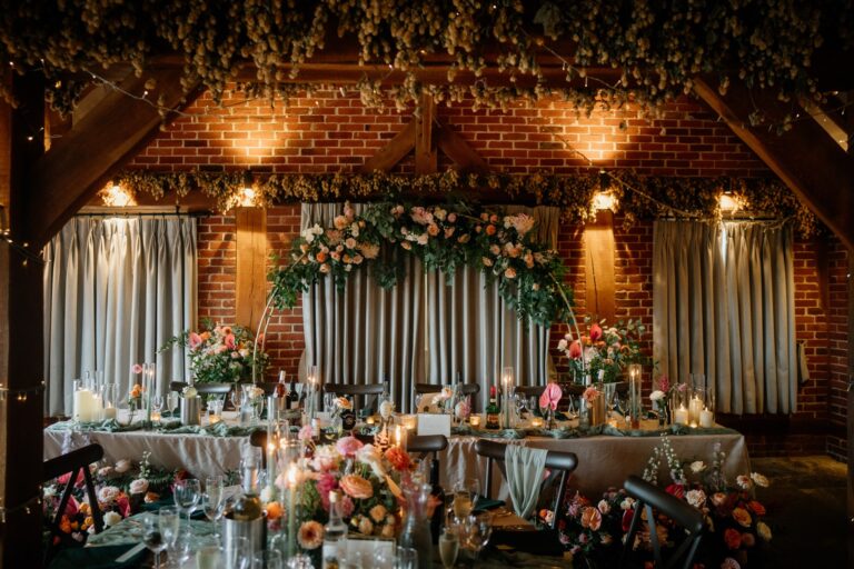 A stunning floral set up for a wedding breakfast at the barn wedding venue, The Ferry House in Kent.