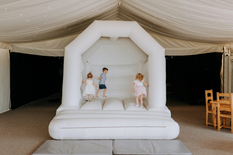 Children playing on a bouncy castle during a christening